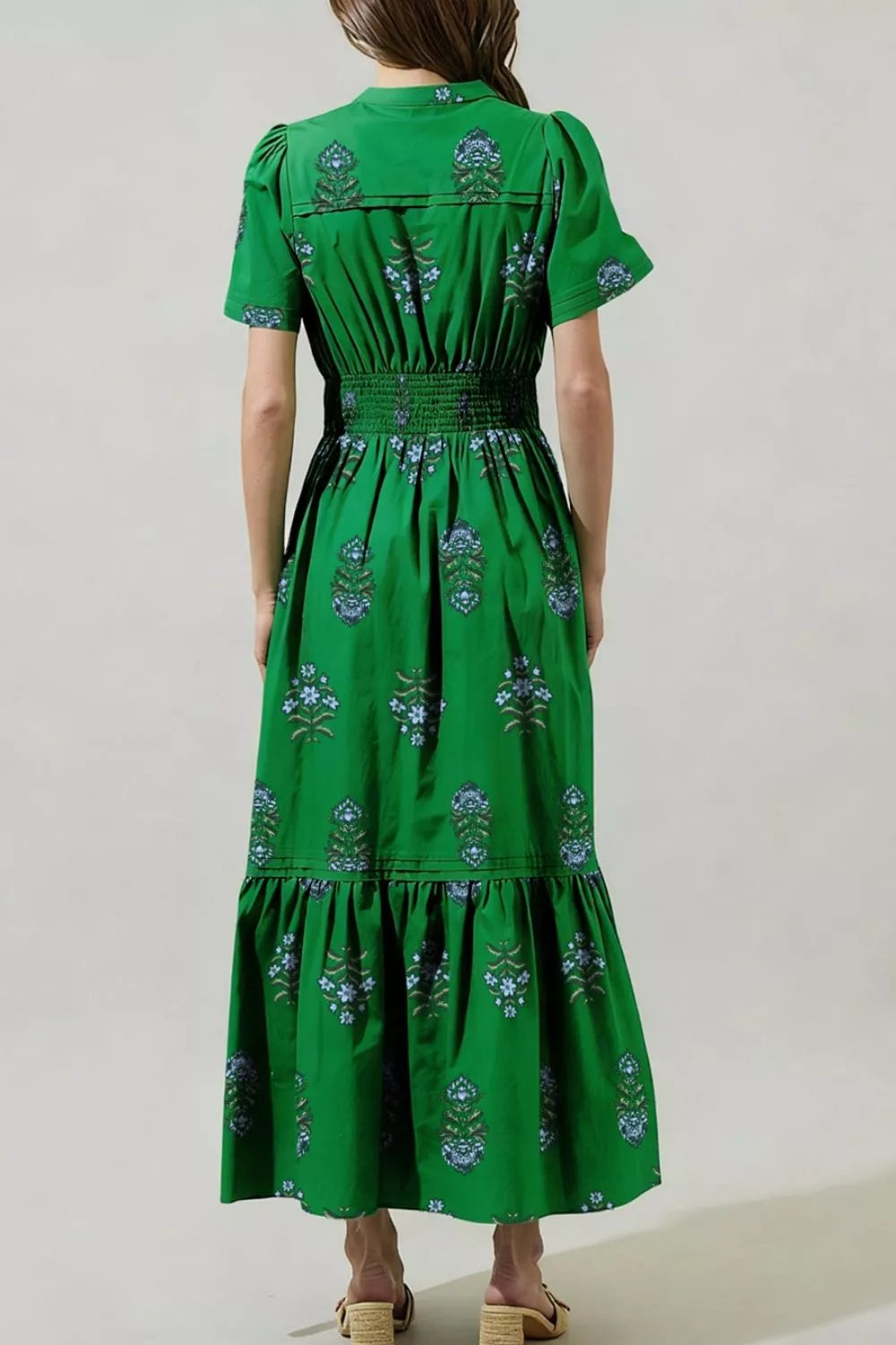 Green cotton maxi dress with smocked waist, puff sleeves, tiered hem, and blue floral print.