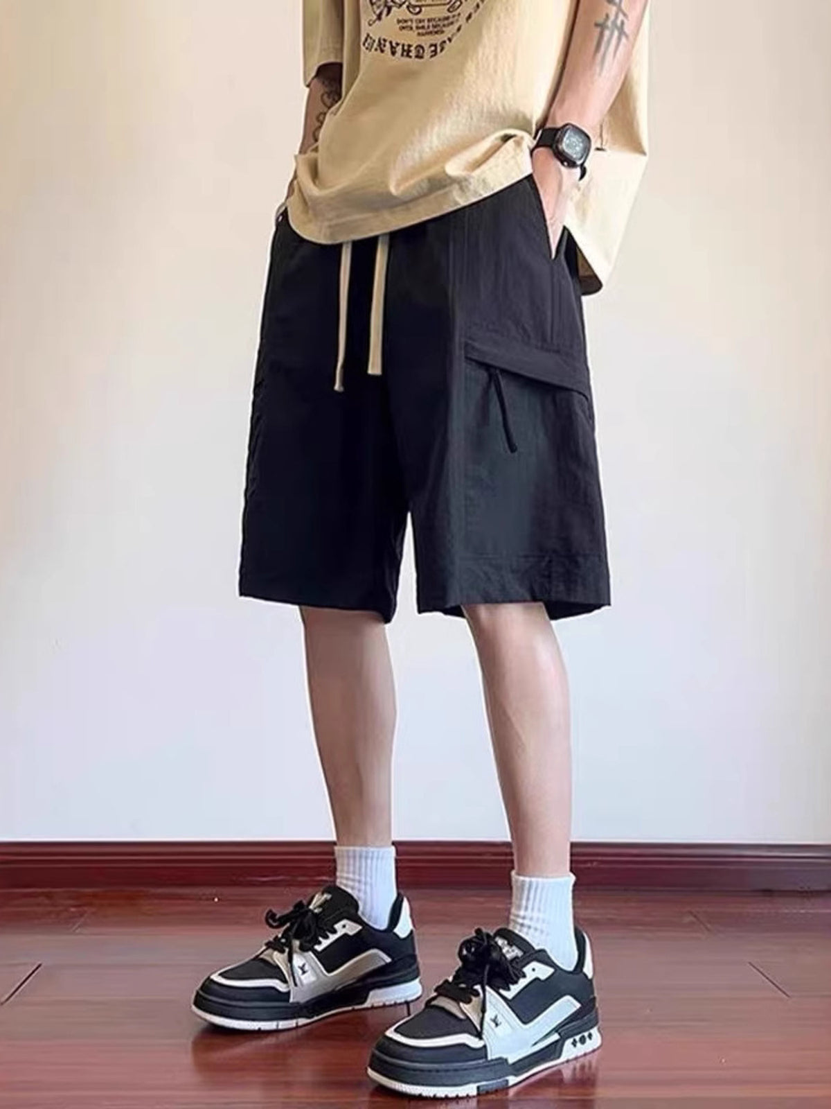 Men's black relaxed fit cargo shorts with drawstring and flap pocket detail.