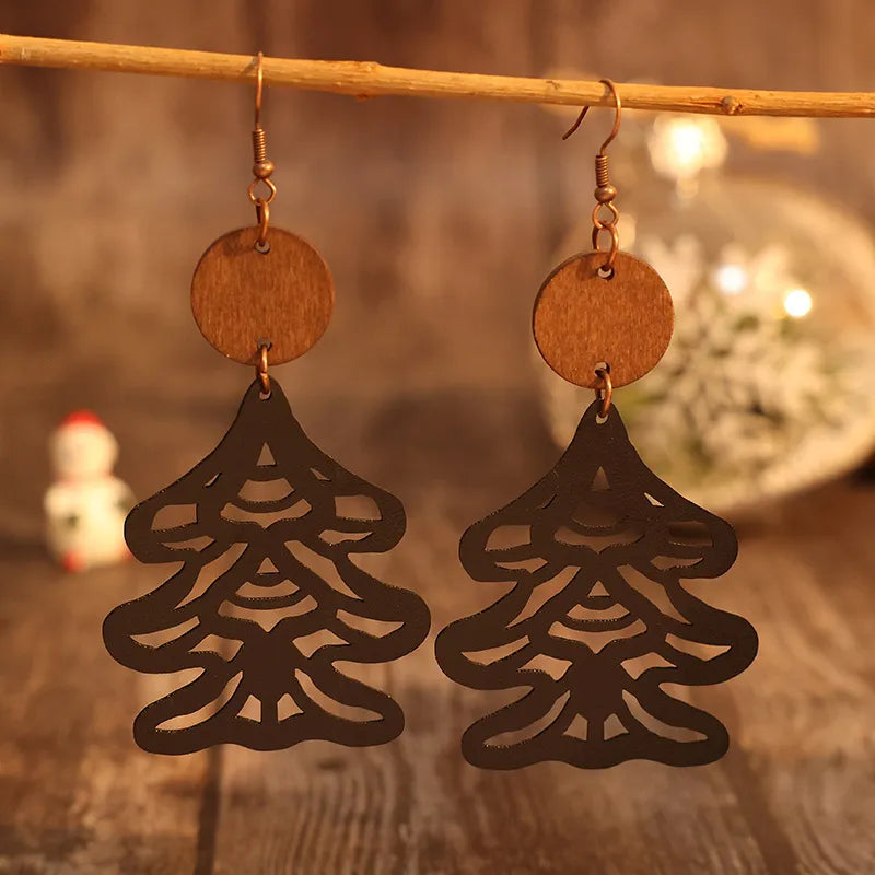 Black laser-cut pine tree earrings with wooden circle tops.