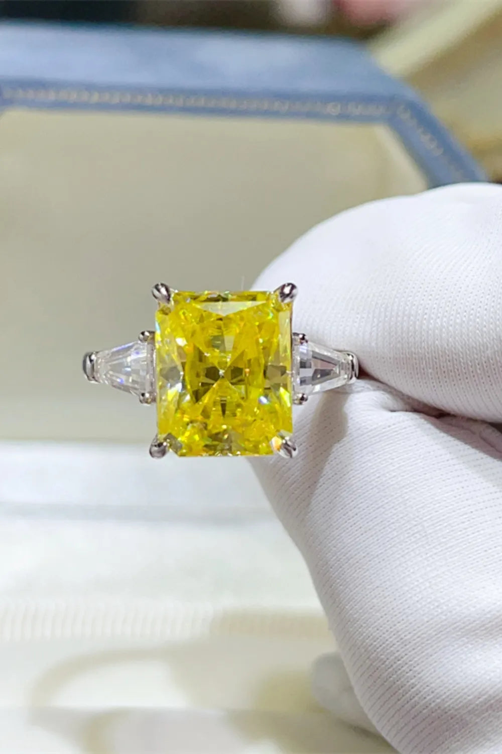 Canary yellow emerald cut ring with side trapezoid stones on a silver band