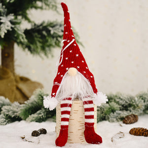Red knitted gnome ornament with white hearts, striped socks, and fluffy white beard.