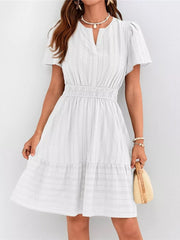 White textured V-neck tiered dress with smocked waist and short sleeves.
