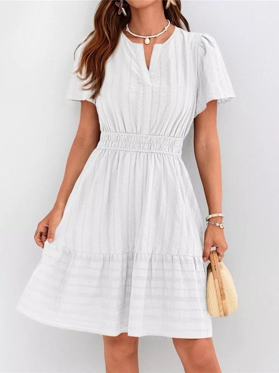 White textured V-neck tiered dress with smocked waist and short sleeves.