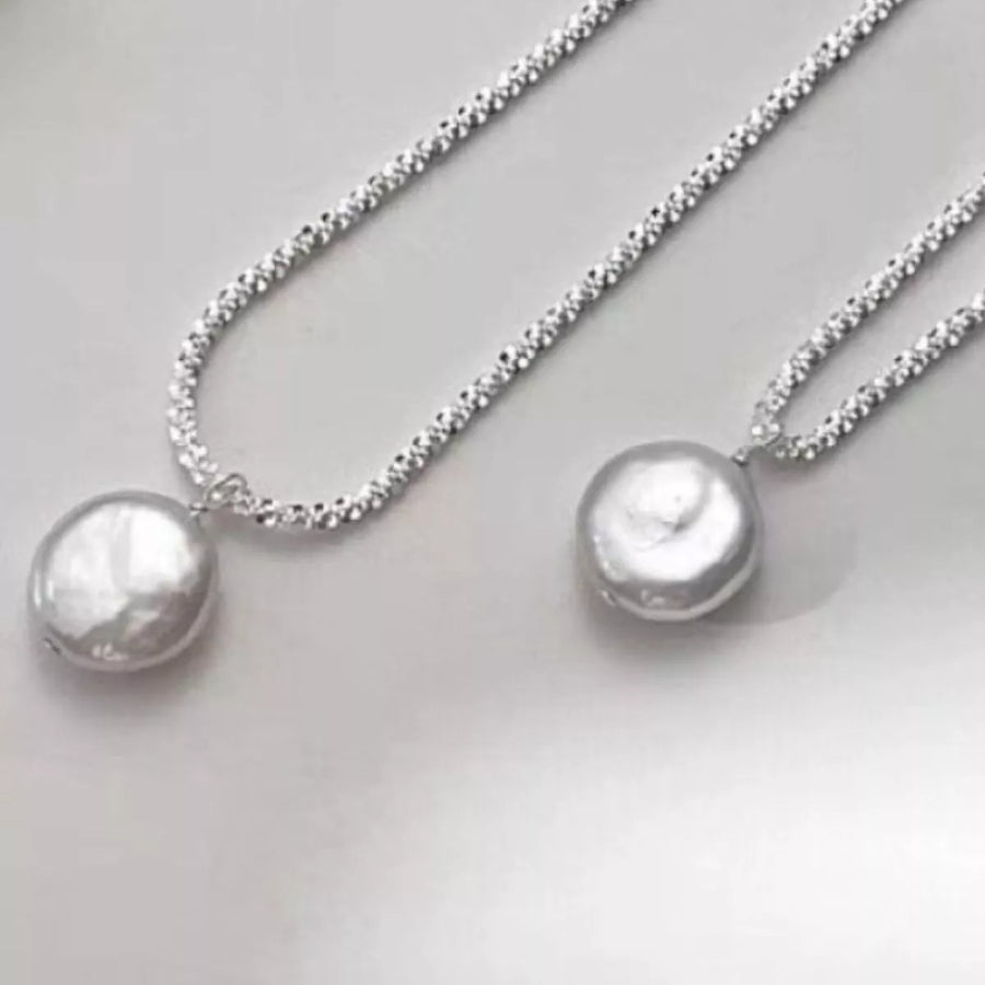 Silver pearl pendant necklace with a textured chain.