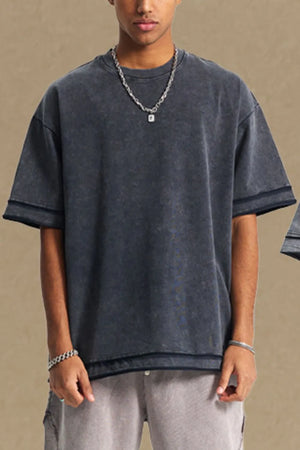 Washed cotton tee in dark gray with raw edges and a relaxed fit.