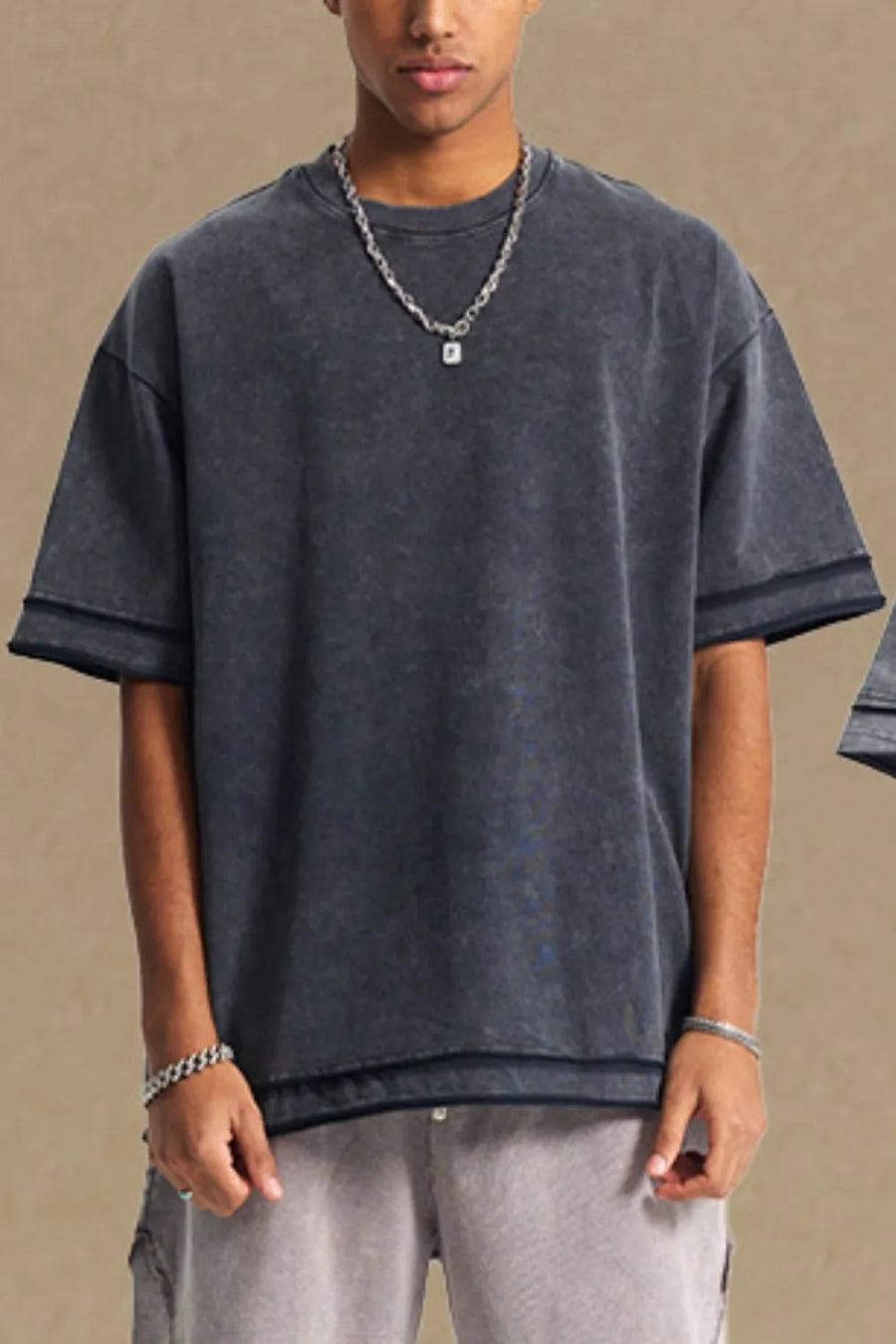 Washed cotton tee in dark gray with raw edges and a relaxed fit.