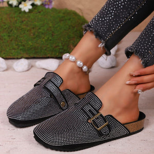 Black rhinestone buckle slip-on mules with cork sole.