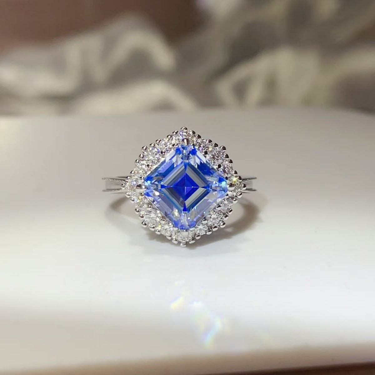 ring in sapphire blue featuring halo setting and square halo fit