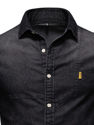 Dark wash denim shirt with asymmetric pocket detail and button-down front.