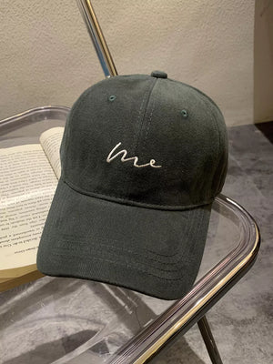 Embroidered cotton baseball cap in grey with curved brim and white "me" text detail.