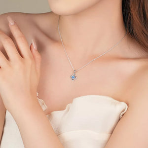 Delicate silver four-leaf clover necklace with blue stone charm on a sterling silver chain.
