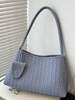 Blue woven shoulder bag with braided strap and leather tag detail