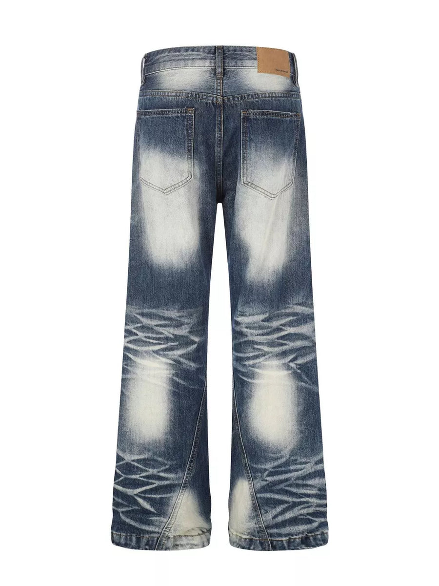 Distressed blue bootcut jeans with faded wash and textured detailing.
