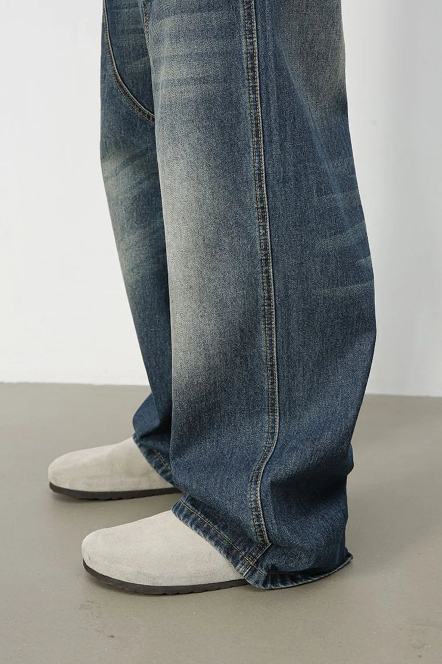 Artisan distressed wide-leg jeans in medium wash denim, showing relaxed fit and frayed hem.
