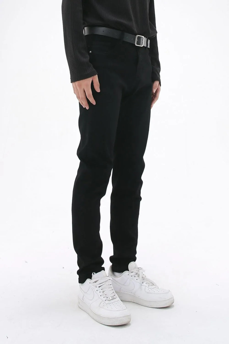 Black slim-fit stretch denim trousers with a black belt.