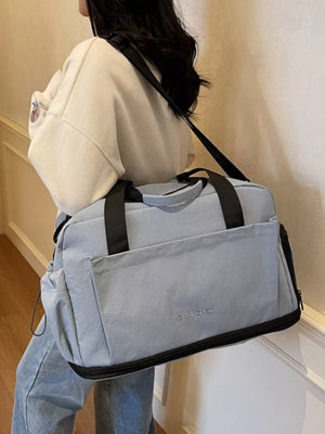 Blue Oxford cloth travel tote bag with black trim and shoulder strap.