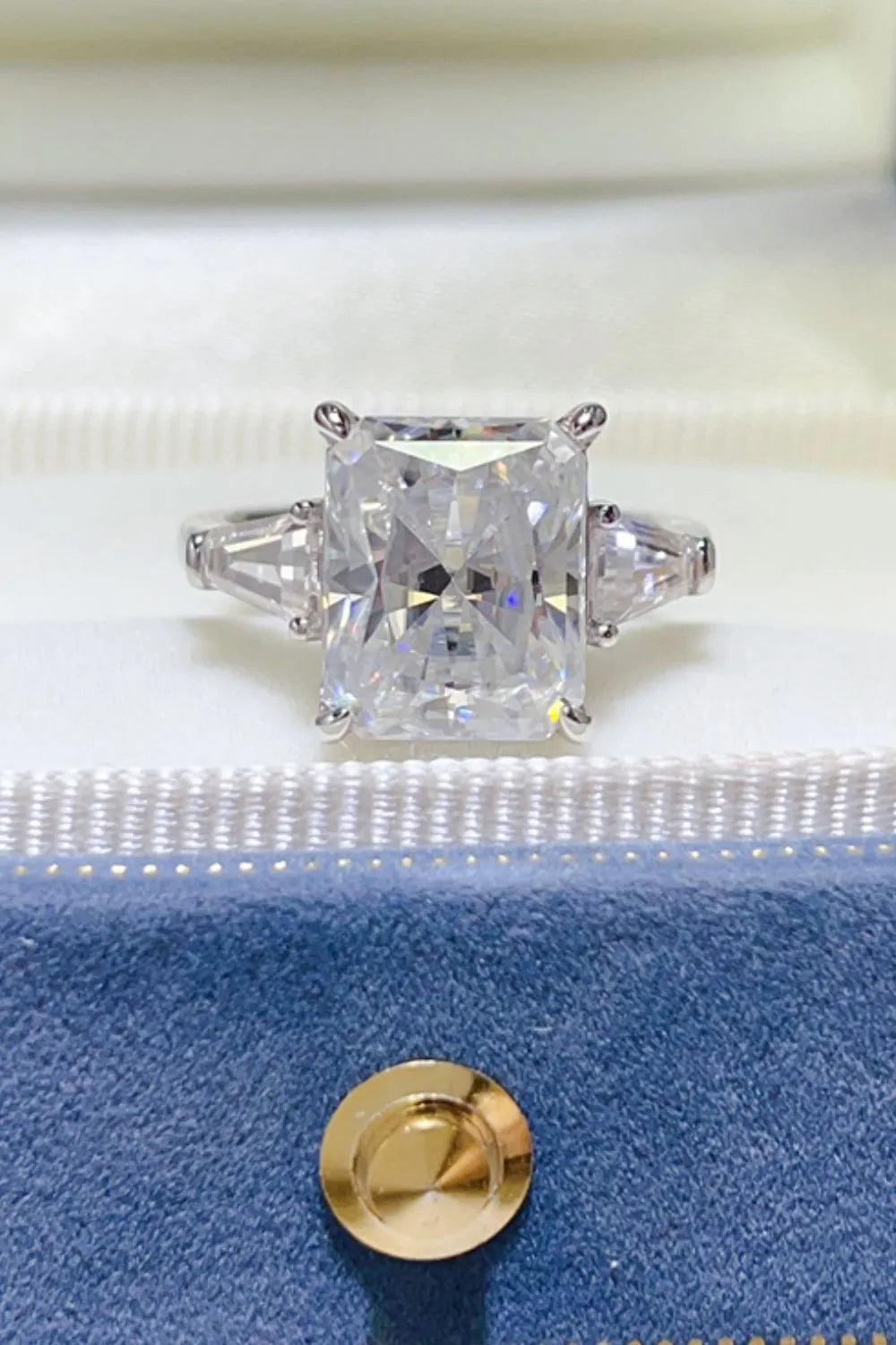Radiant cut moissanite ring in silver with side trapezoid stones.