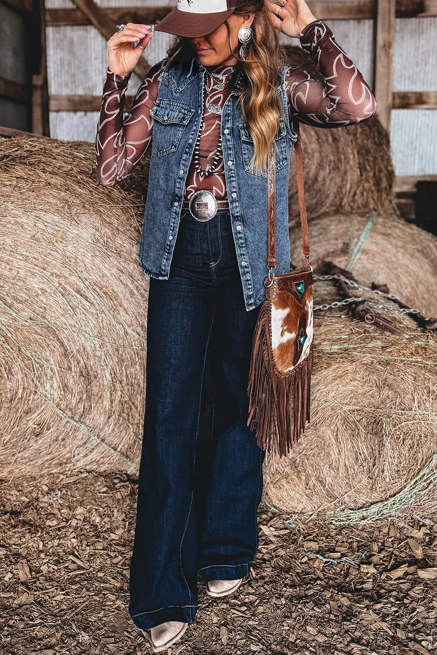 Blue solid denim button front sleeveless vest with pockets, styled with a western patterned top and jeans.
