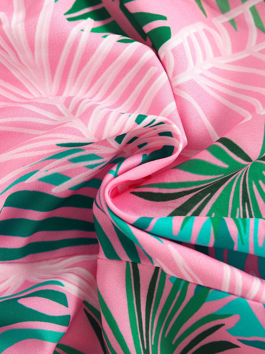 Pink cotton baby top with a tropical floral print and asymmetrical design.
