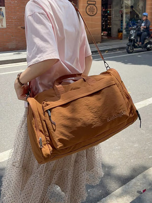Caramel Oxford cloth travel bag with detachable strap and zippered pockets.
