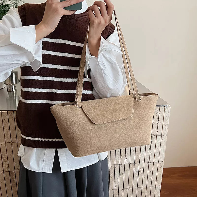 Sleek khaki suede flap tote bag with shoulder straps.
