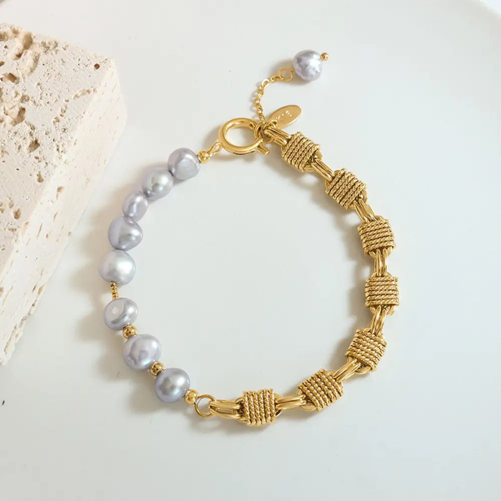 Gold bracelet with asymmetrical pearl and knotwork chain details