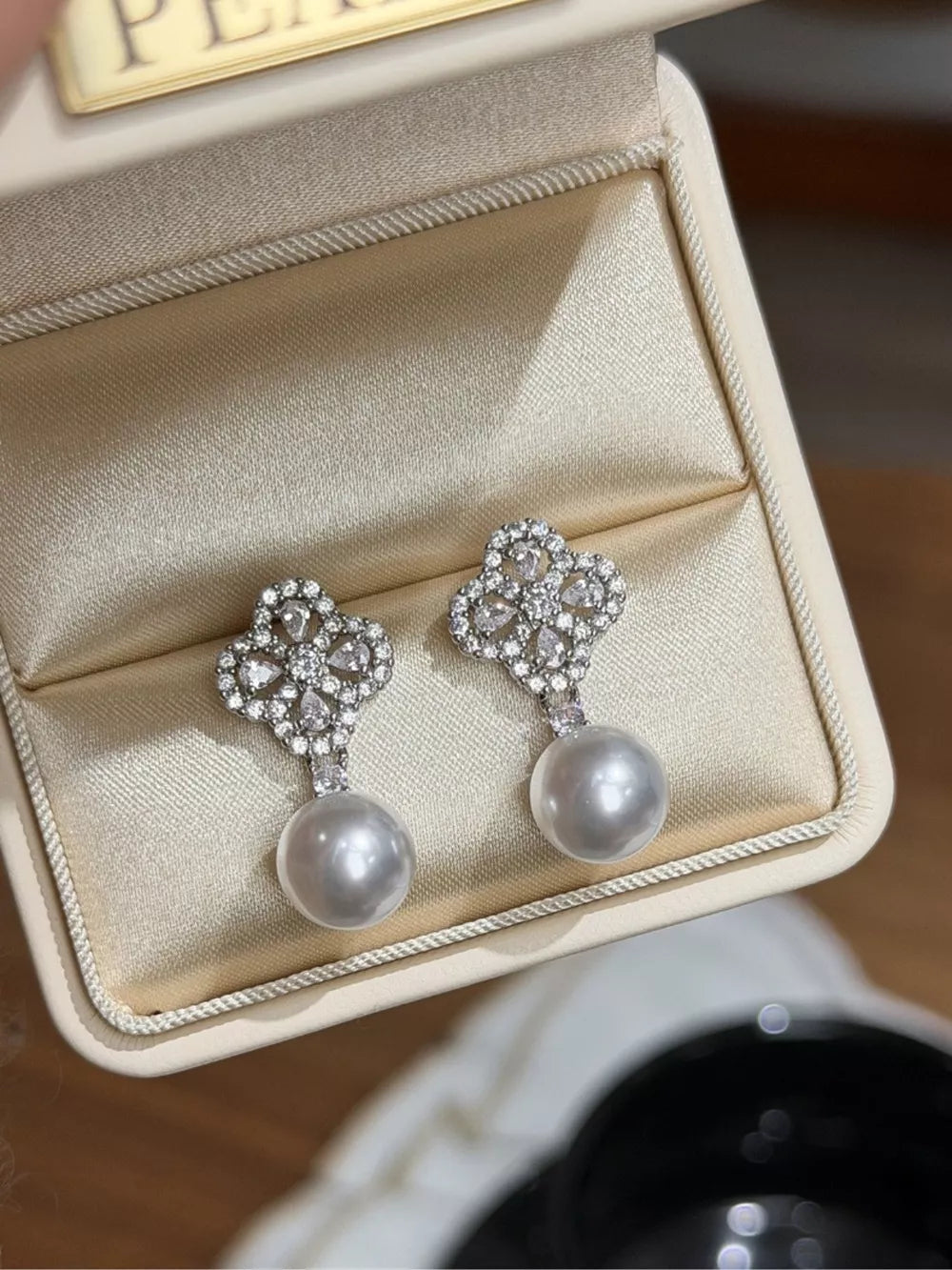 Elegant clover zircon and pearl drop earrings with a beige pearl.