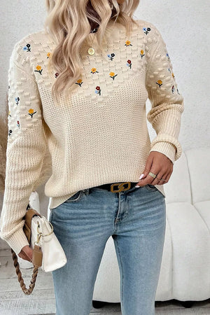 Beige embroidered round-neck sweater with dropped shoulders and a checkered pattern detail.