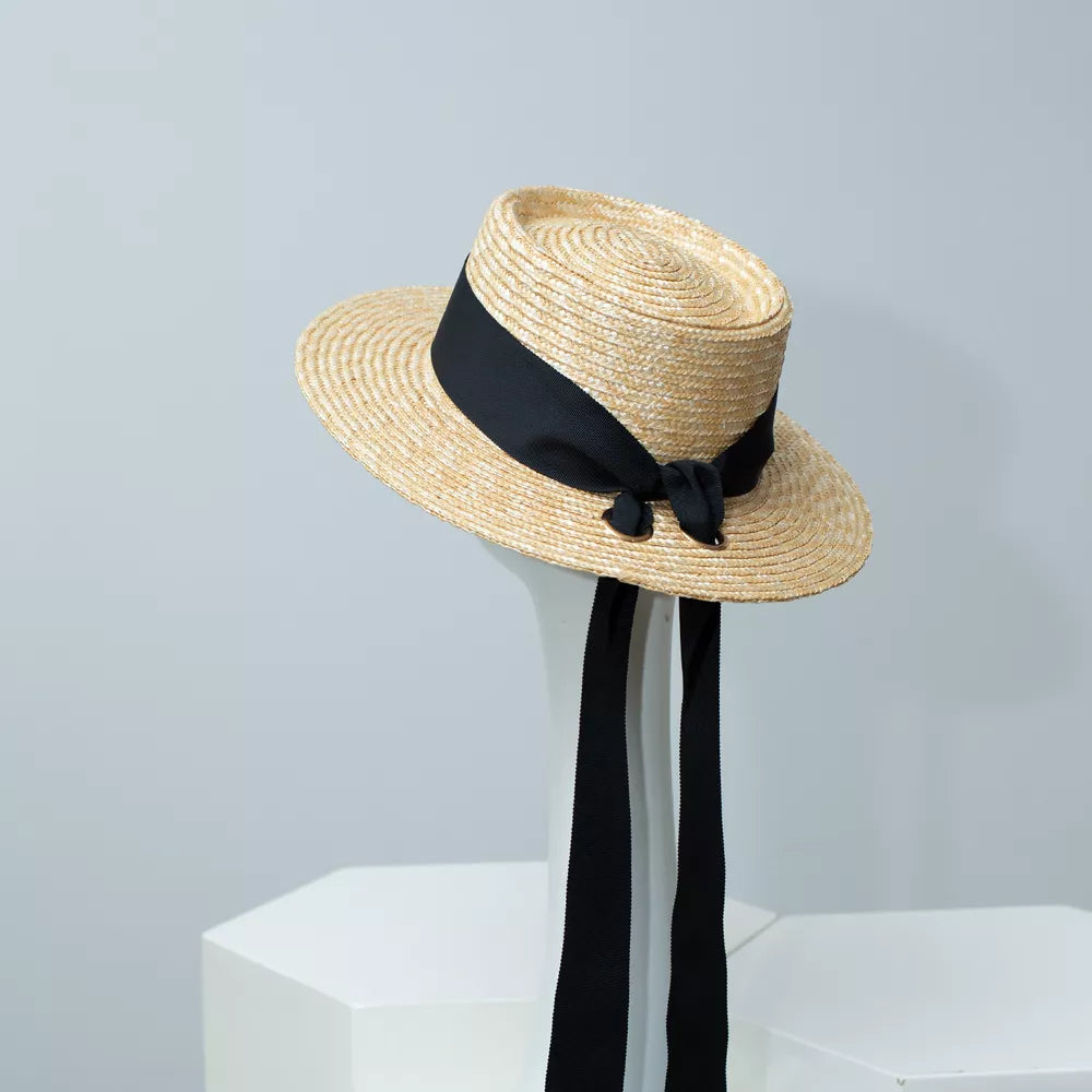 Classic straw boater hat with black ribbon and long ties.