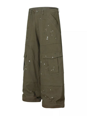 Olive green cotton cargo pants with white paint splatter design and button fly.