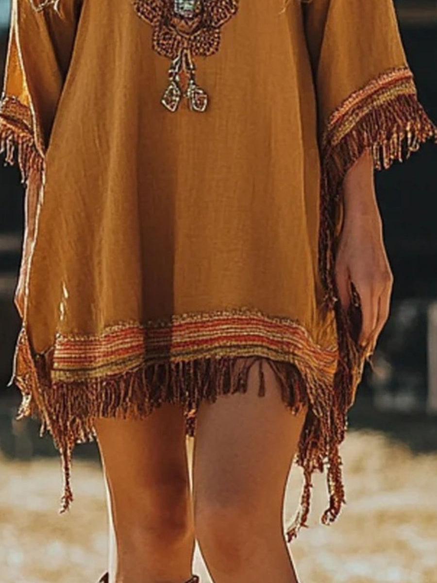 Embroidered bohemian mini dress in mustard yellow with fringe trim and colorful woven details.