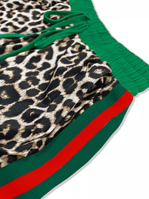Leopard print lounge pants with green drawstring and green stripe trim with red detail.