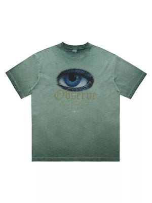 Green graphic t-shirt with an eye print and "Observe" text