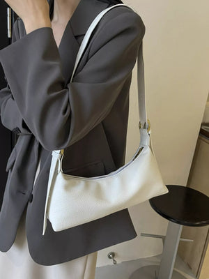 Minimalist white PU leather crossbody bag with adjustable strap and gold hardware detail.
