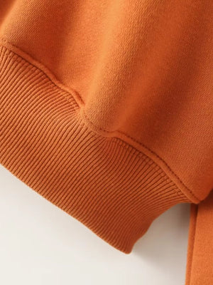 Orange casual zip-up top detail with ribbed cuff and stitching