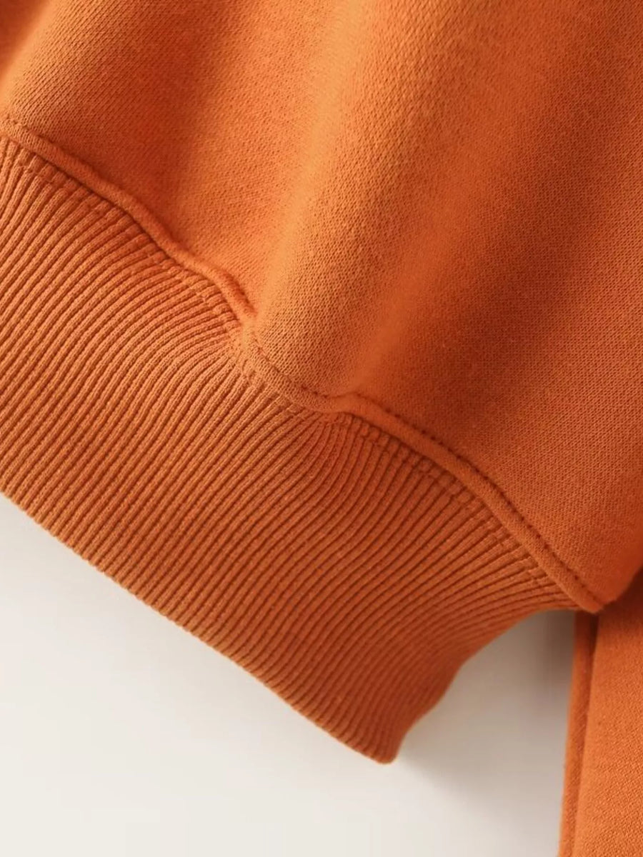 Orange casual zip-up top detail with ribbed cuff and stitching