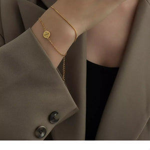 Gold double layered titanium steel bracelet with circular charm and adjustable chain