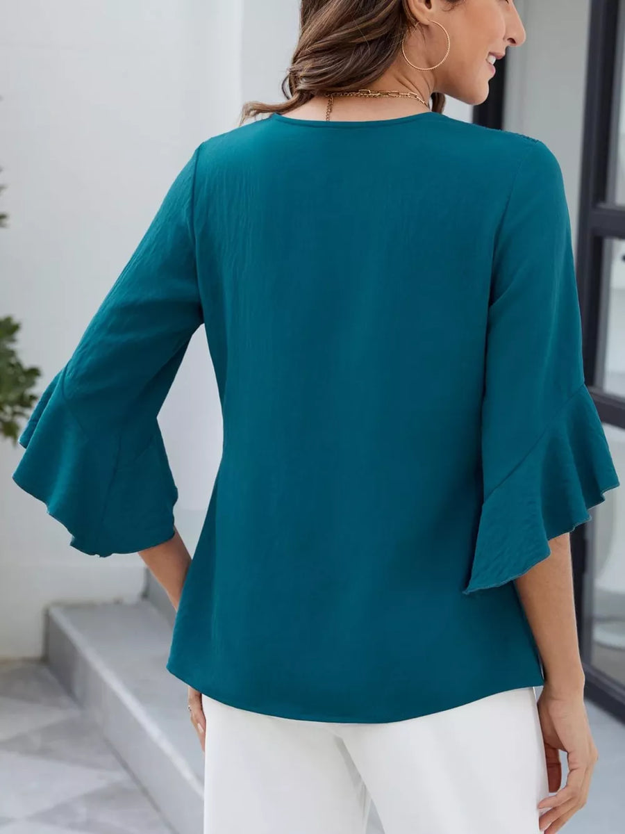 Teal V-neck blouse with ruffle sleeves and textured fabric.