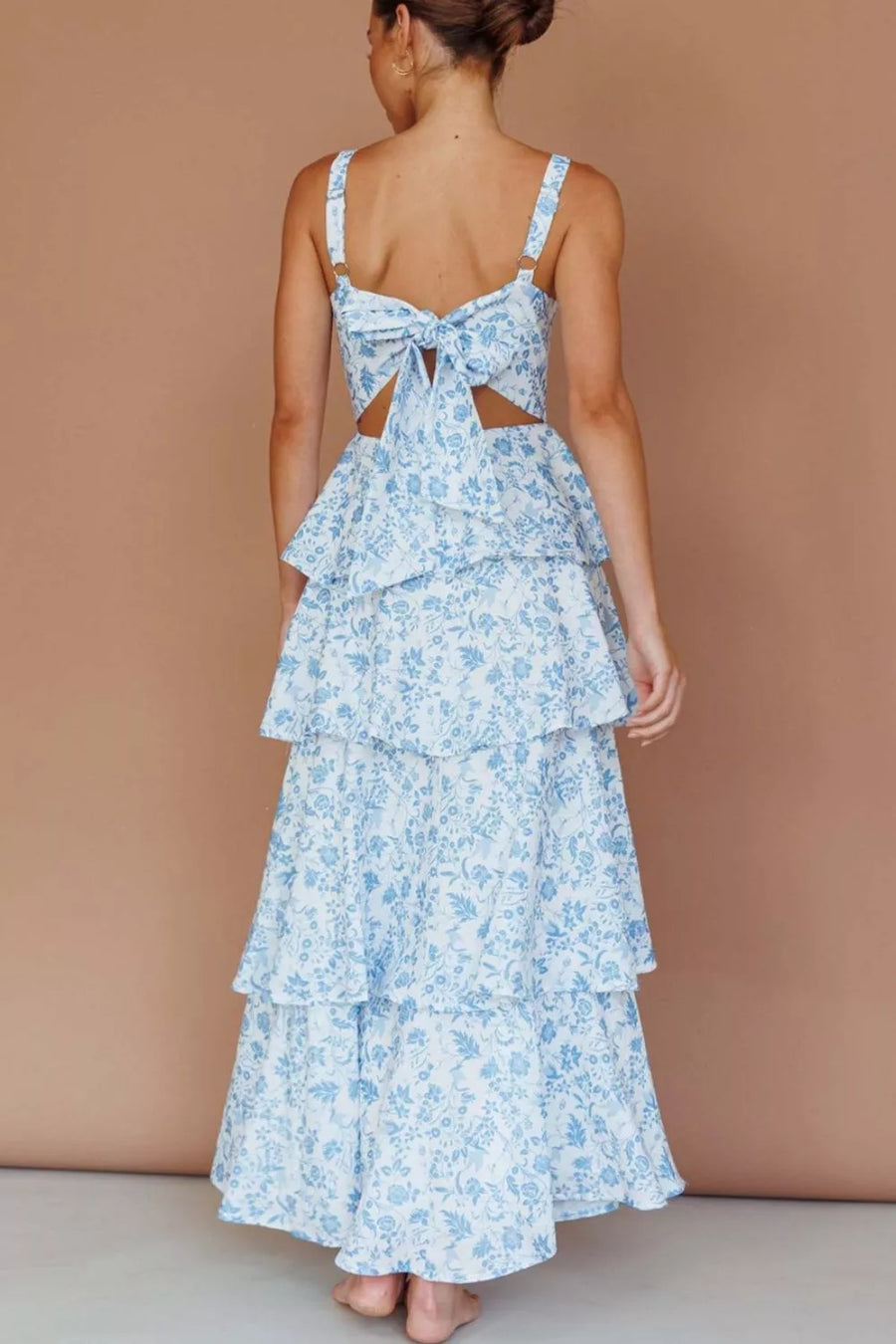 Maxi dress with blue floral print, tiered skirt, and back bow detail.