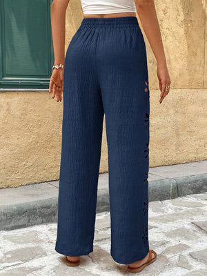 Navy wide leg pants with floral cutouts on the side seam and elastic waist