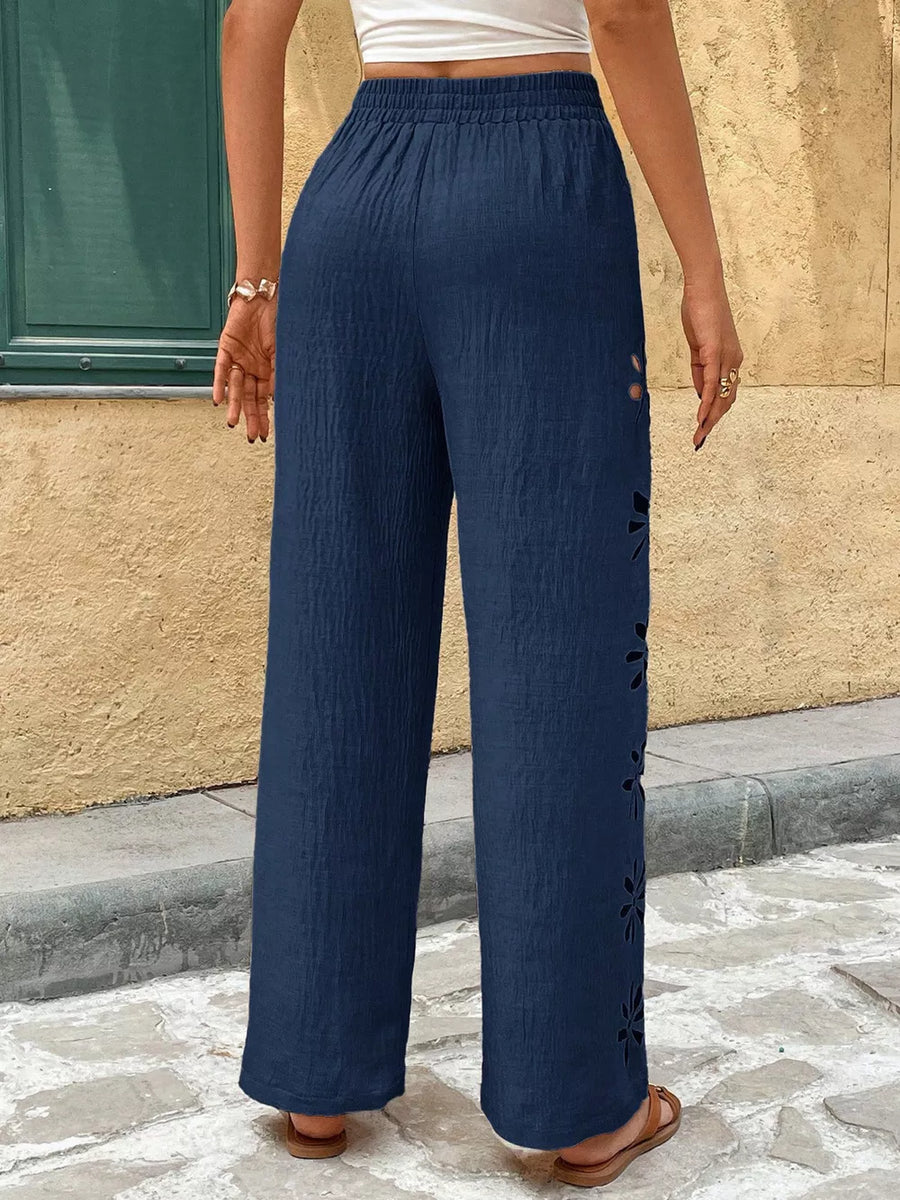 Navy wide leg pants with floral cutouts on the side seam and elastic waist