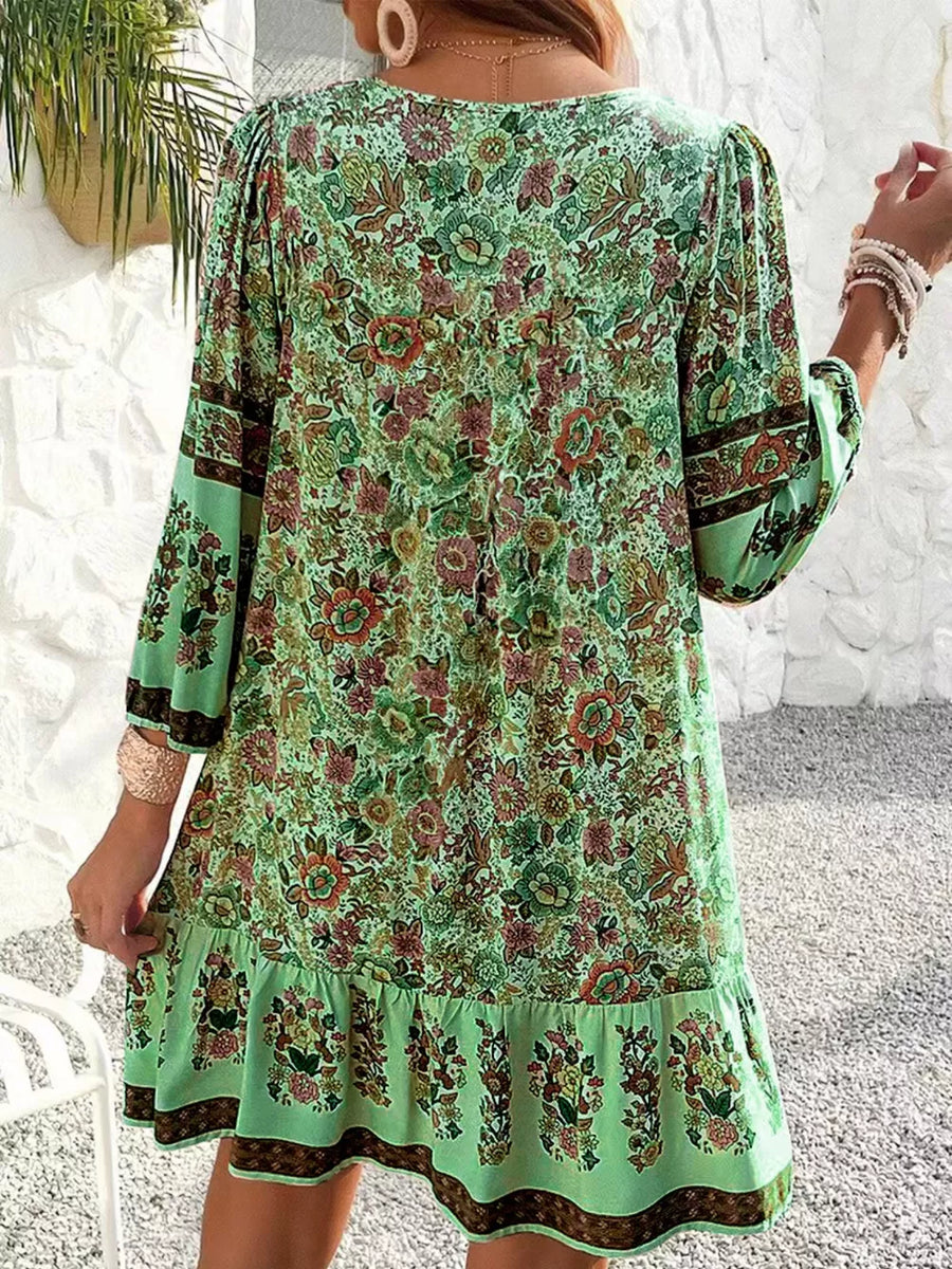 Matcha green floral print mini dress with tiered ruffle hem and tassel tie detail.
