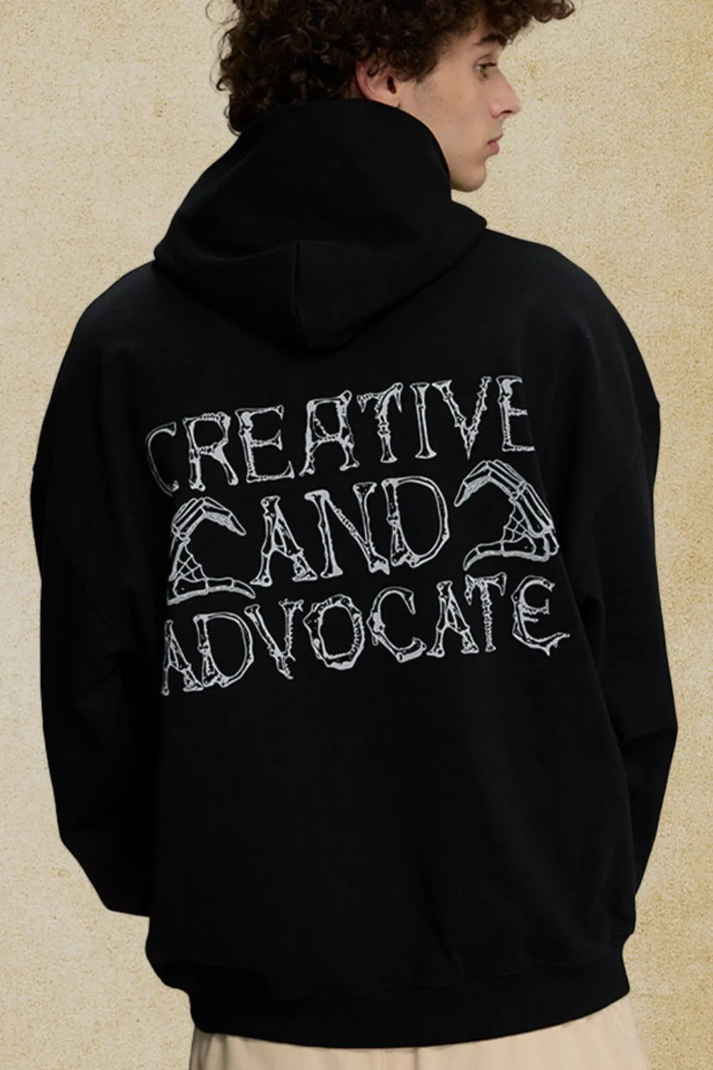 Black oversized hoodie with embroidered text and skeleton hand graphic on back
