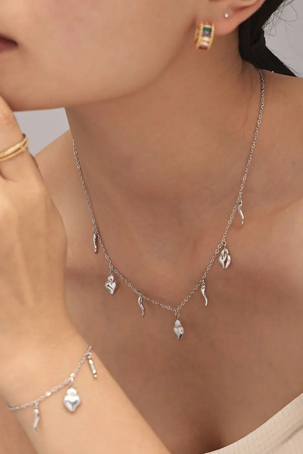 Silver charm jewelry set with sacred hearts and horns, 18K gold-plated
