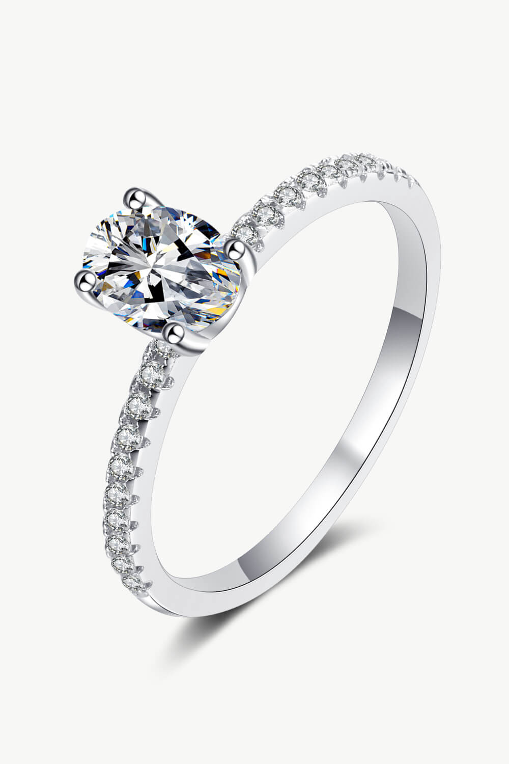 Silver moissanite ring with pavé band and oval center stone.