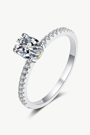 Silver moissanite ring with pavé band and oval center stone.
