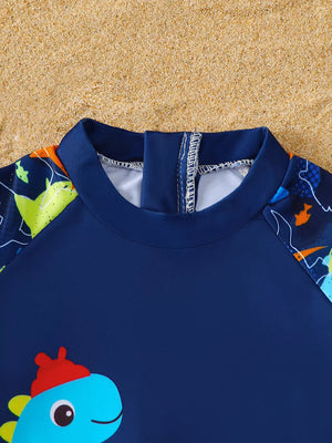 Baby boys' navy rash guard with playful dinosaur print on sleeves and front.
