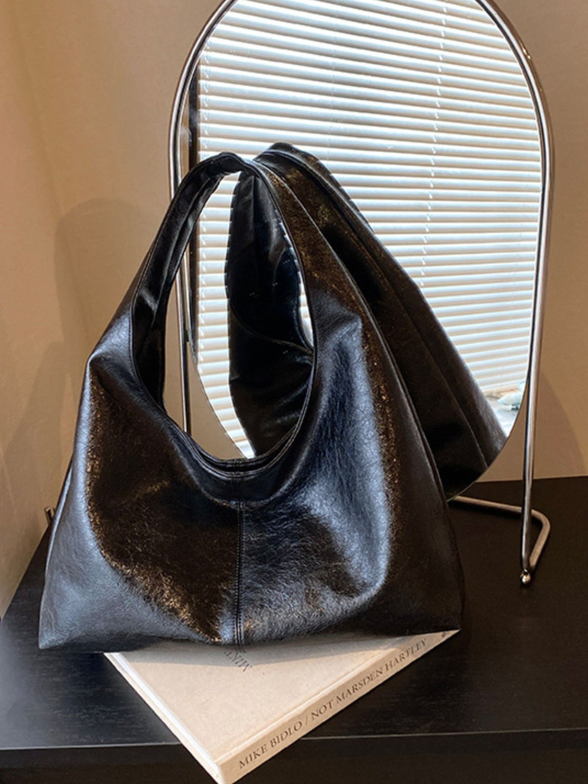 shoulder bag in black featuring shoulder strap and relaxed fit