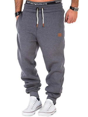 Gray relaxed fit joggers with leather detail and drawstring waist.