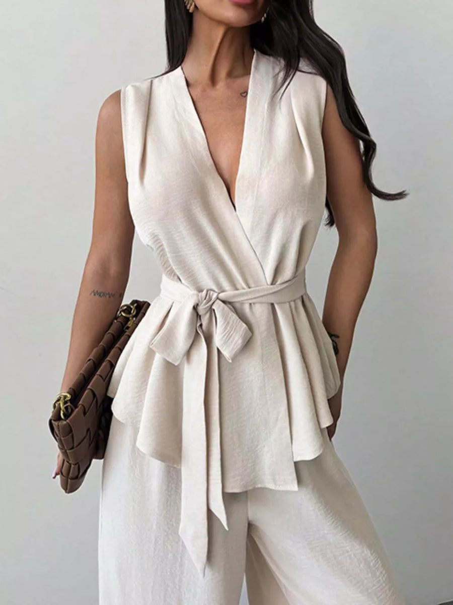 Sleeveless wrap top with tie waist and wide-leg pants set in cream polyester.
